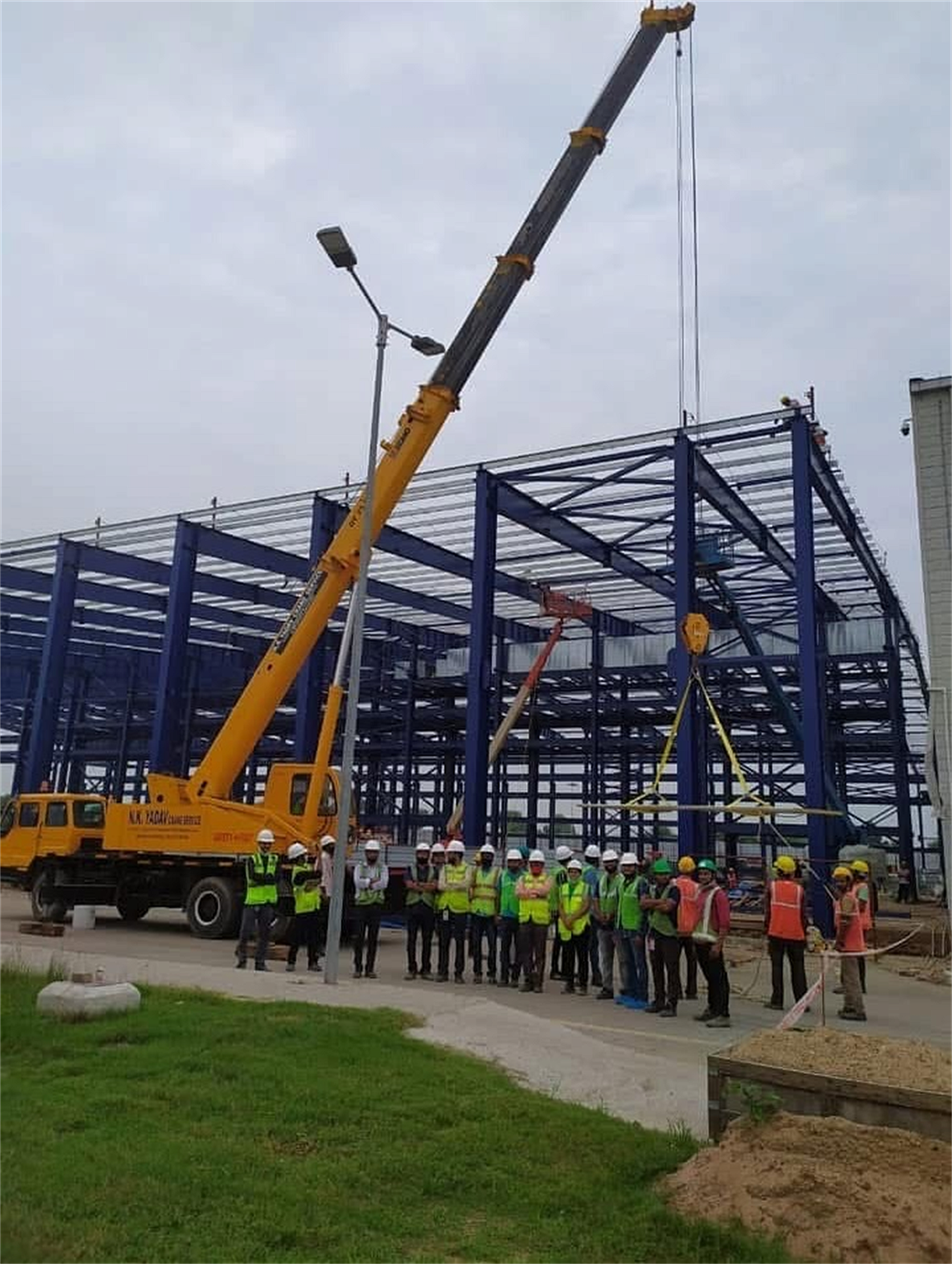 Nrupur Projects real blue PEB steel structure under construction by heavy cranes
